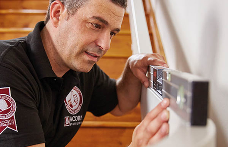 Stairlift Technician Measuring Stair Rail for Stairlift To Be Installed