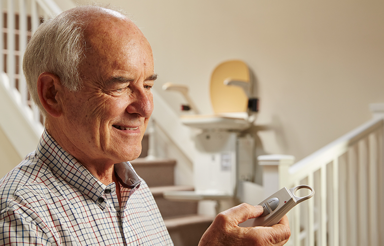 Acorn Stairlifts Customer Using Remote To Control Stairlift To Go Up And Down